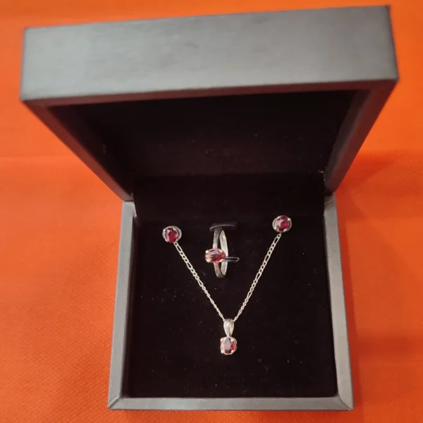 Red garnet handcrafted jewelry set made of silver with matching ring, pendant, and earrings.