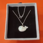 Silver 925 chain with mother of pearl fish pendant on black background