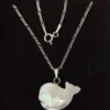 Close-up of mother of pearl fish pendant on sterling silver chain