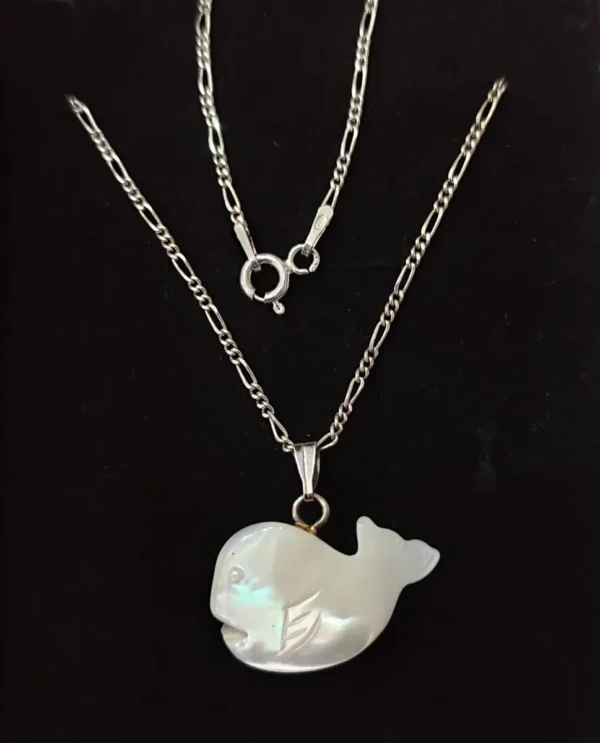 Close-up of mother of pearl fish pendant on sterling silver chain